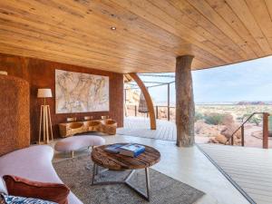 a living room with a table and a view of the desert at Onduli Ridge in Twyfelfontein