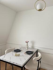 a dining room table with two chairs and a white table at Suite Secrète in Sélestat +7 photos