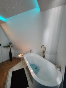 a white bath tub in a bathroom with blue lights at Suite Secrète in Sélestat
