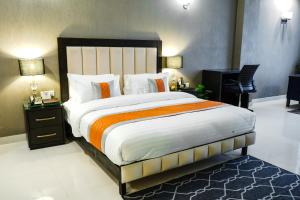 a bedroom with a large bed and a desk at Best Western Faisalabad in Faisalabad