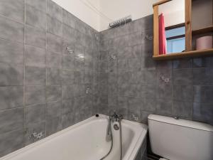a bathroom with a white tub and a toilet at Studio rénové à Tignes Le Lac, proche pistes et commerces, balcon et terrasse privative - FR-1-502-425 in Tignes