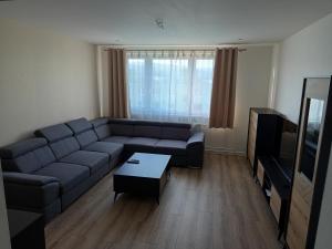 a living room with a couch and a tv at Apartmán s 2 spálňami in Prievidza