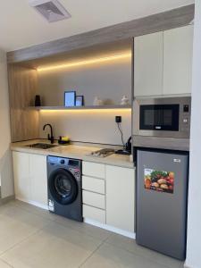 a kitchen with a washing machine and a microwave at شفق in Ash Shafa