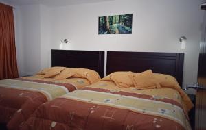 two beds sitting next to each other in a bedroom at Hotel Avanty in Ipiales