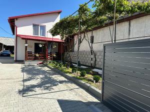 a house with a gate in front of a driveway at Casa Cu Vie in Topliţa