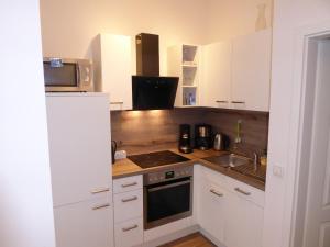 a kitchen with white cabinets and a stove top oven at Bright & friendly flat in downtown Duisburg - "Miner Mates Home" from revierquartier boutique apartments in Duisburg
