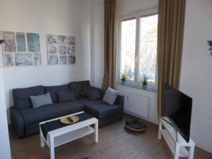 a living room with a couch and a tv at Bright & friendly flat in downtown Duisburg - "Miner Mates Home" from revierquartier boutique apartments in Duisburg