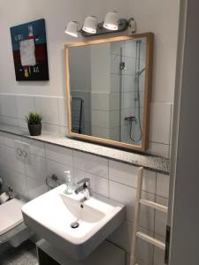 a bathroom with a sink and a mirror at Bright & friendly flat in downtown Duisburg - "Miner Mates Home" from revierquartier boutique apartments in Duisburg +4 photos