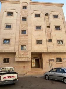 a building with two cars parked in front of it at قصر الضيافه in Al Madinah