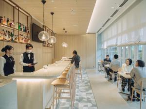 a restaurant with people sitting at tables and a bar at Wishton Hotel Yukari in Sakura +76 photos