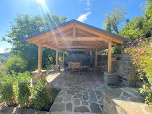 a wooden pergola with a table and a bench at Vila Korchari Dardhe in Korçë