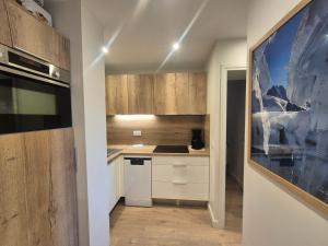 a small kitchen with wooden cabinets and a stove at Appartement lumineux skis aux pieds avec balcon - FR-1-502-541 in Tignes