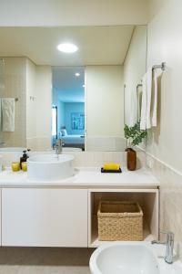 a white bathroom with two sinks and a mirror at Ocean Living by MP in Vila Nova de Gaia +45 photos