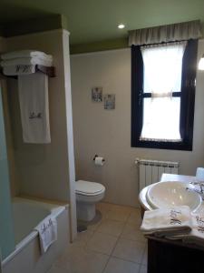 a bathroom with a sink and a toilet and a window at Apartamentos la Marina in Ribadesella