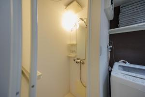 a bathroom with a light next to a washing machine at Cruise Inn Kitasenju Station Front1 in Tokyo
