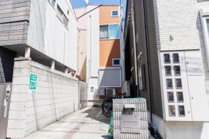 an alley between two buildings with a bike parked on the sidewalk at Cruise Inn Kitasenju Station Front1 in Tokyo
