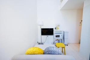 a bedroom with a bed and a yellow chair at Cruise Inn Kitasenju Station Front1 in Tokyo
