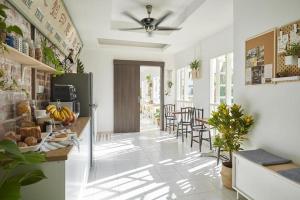 a kitchen with a counter and chairs in a room at Sleepy Nomad Hostel in Melaka