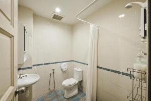 a bathroom with a toilet and a sink at Sleepy Nomad Hostel in Melaka