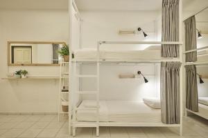 a room with two bunk beds and a mirror at Sleepy Nomad Hostel in Melaka