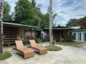 Tribal Xperience Guesthouse في سان فيسنتي: وجود كرسيين امام المبنى