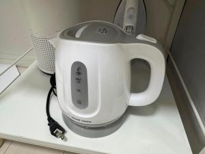 a white tea kettle sitting on top of a counter at Cruise Inn Kitasenju Station Front1 in Tokyo +15 photos