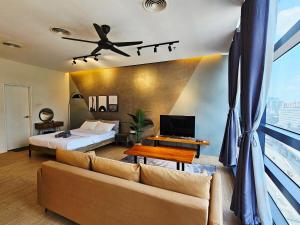 a bedroom with a couch and a bed and a window at Metro Studio - Direct LRT access, near Pantai Hospital, University Malaya, Mid Valley, Bangsar in Kuala Lumpur