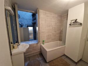 Un baño con bañera blanca y lavabo. en Studio Angela, en Riom