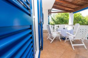 a blue house with a table and chairs on a patio at House Bianca with garden in Malinska
