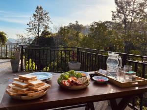 a wooden table with food on top of a balcony at Cabin Alpha in Bandarawela +34 photos