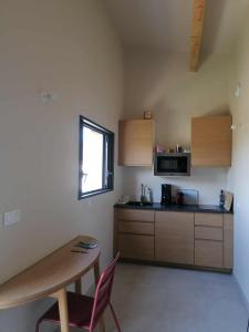 a kitchen with a table and a table and a window at Gite neuf avec accès sauna, bain a remous in Crespian