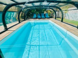 an indoor swimming pool with blue water at Dépendance 2 chambres secteur MEETT in Aussonne