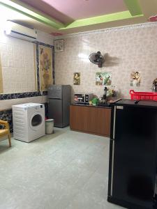 a kitchen with a washing machine and a microwave at Hanh Thông Homestay in Dong Hoi