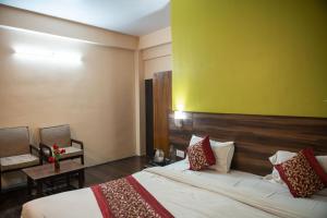 Habitación de hotel con cama y pared amarilla en Baizus Oak, en Gangtok