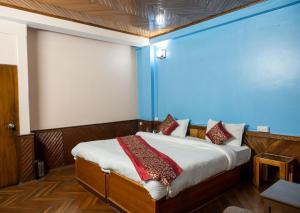 Un dormitorio con una cama con una pared azul. en Baizus Oak, en Gangtok