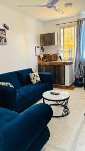 モンバサにあるMaweni Apartmentsの青いソファとテーブルのあるリビングルーム