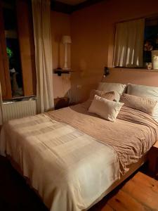 a large white bed in a bedroom with a window at The Beach House in Schellinkhout +62 photos