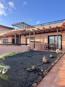 a house with a yard with a patio at Villa Majanicho Pueblo con piscina in Majanicho