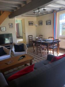 una sala de estar con un sofá y una mesa en Le Côtier, en Margon