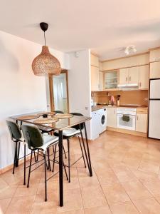 a kitchen with a dining room table and chairs at Villa Majanicho Pueblo con piscina in Majanicho