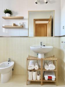a bathroom with a sink and a toilet and a mirror at Villa Majanicho Pueblo con piscina in Majanicho