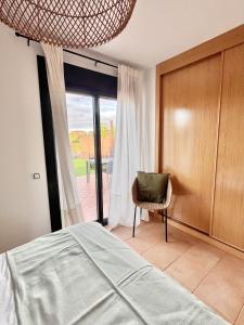 a bedroom with a bed and a chair and a window at Villa Majanicho Pueblo con piscina in Majanicho