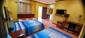 a hotel room with two beds and a television at La Traviesa Hotel Resort in General Trias