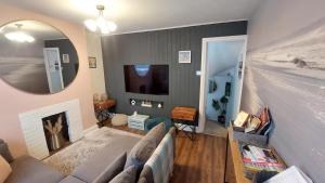 a living room with a couch and a mirror at Clifftop Mews - Westcliff - Ramsgate - Pet friendly! in Kent