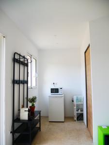 a room with a white wall and a microwave at Studio à la campagne in Aubignan