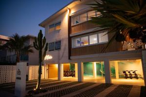 a large white building with glass windows and a palm tree at El Parche Bilinga Beachside in Gold Coast