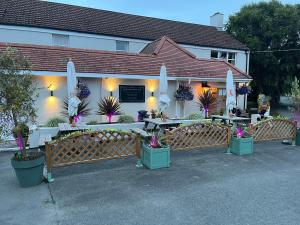 a restaurant with tables and umbrellas in front of it at Longfrie Inn in St Saviour Guernsey