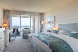 een hotelkamer met een groot bed en een balkon bij Strandhotel Dünenmeer - Adults only in Dierhagen