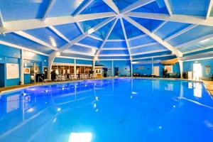 a large swimming pool with a large ceiling at Pocono Mountain Escape - Steps to Lake- Hot Tub - Games- 9 Mins to Ski Slopes! in Long Pond