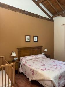 a bedroom with a bed and two lamps on the wall at Casa Rural Concejo 1 in La Adrada